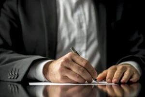 Suited person signing a document